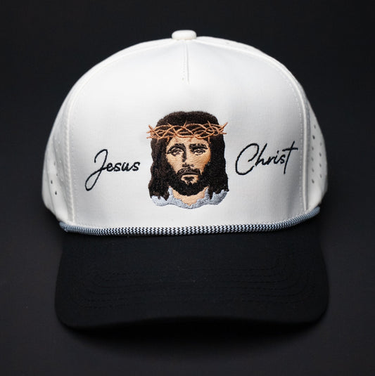 White cap with an embroidered design of Jesus Christ on a black background